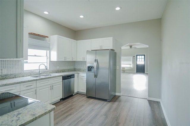 kitchen featuring a sink, white cabinetry, appliances with stainless steel finishes, and tasteful backsplash