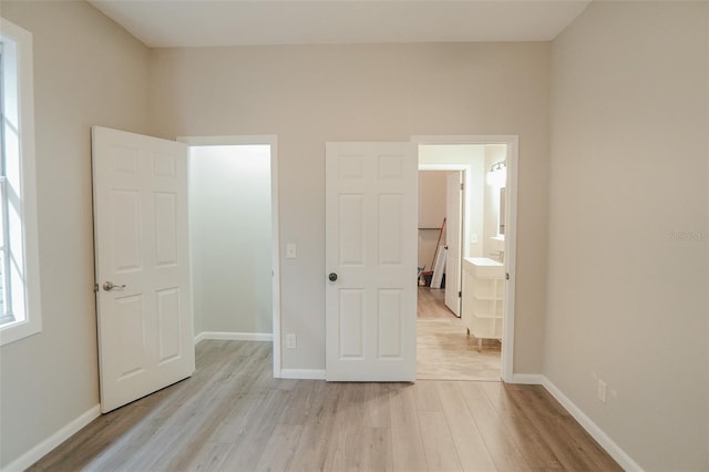unfurnished bedroom featuring light wood-style flooring and baseboards