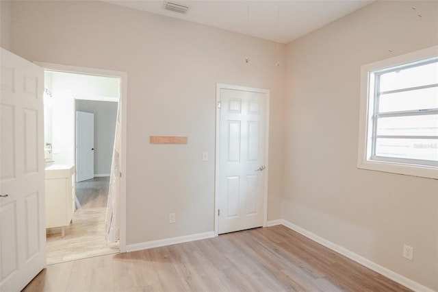 unfurnished bedroom featuring baseboards, visible vents, and light wood-type flooring