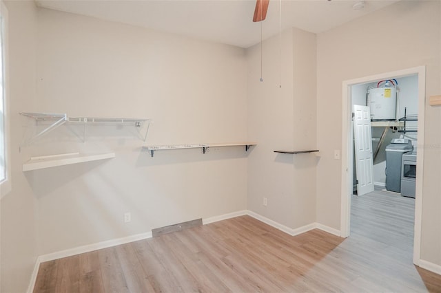 walk in closet with water heater, wood finished floors, ceiling fan, and washer / clothes dryer