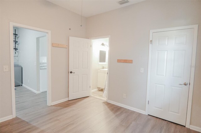unfurnished bedroom with baseboards and light wood-style floors
