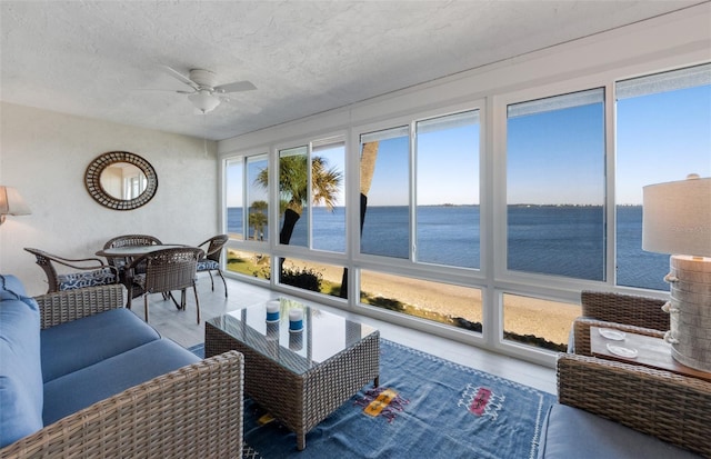 sunroom featuring a water view
