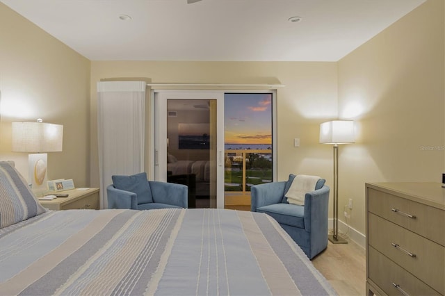 bedroom featuring access to outside, baseboards, and light wood finished floors
