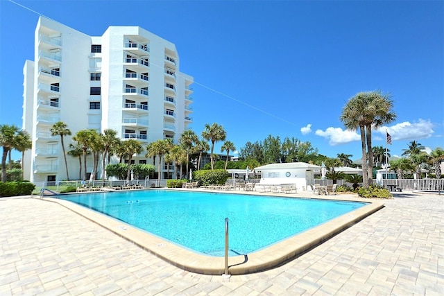community pool with fence and a patio