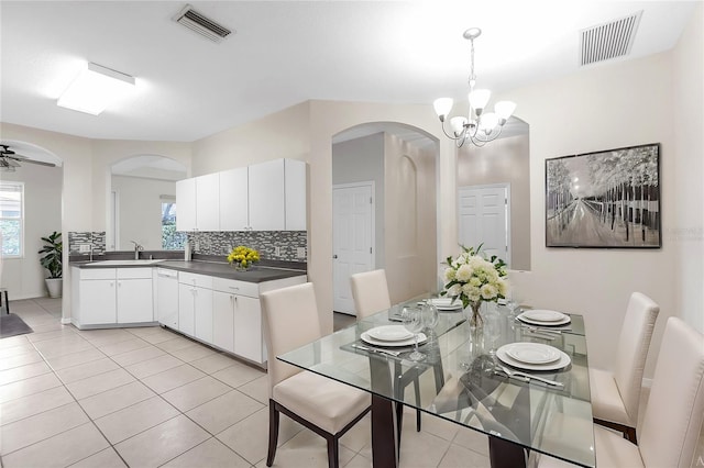 dining space featuring a chandelier, arched walkways, light tile patterned floors, and visible vents