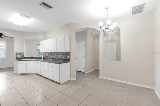 kitchen with tasteful backsplash, visible vents, white cabinetry, and dark countertops