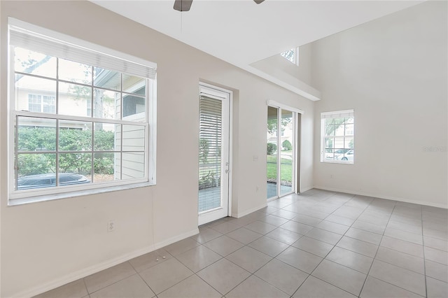 empty room featuring light tile patterned floors, baseboards, and a ceiling fan