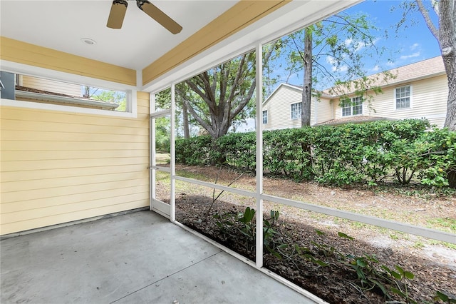 unfurnished sunroom with ceiling fan