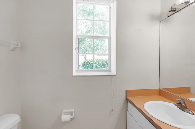 half bathroom featuring vanity and toilet