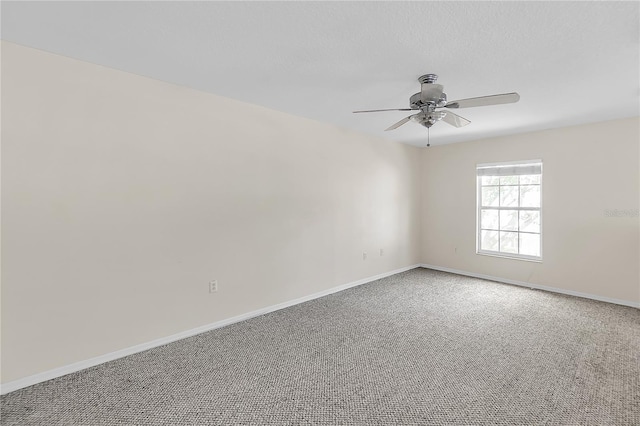 carpeted empty room with baseboards and a ceiling fan