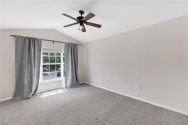 carpeted spare room with ceiling fan, baseboards, and vaulted ceiling