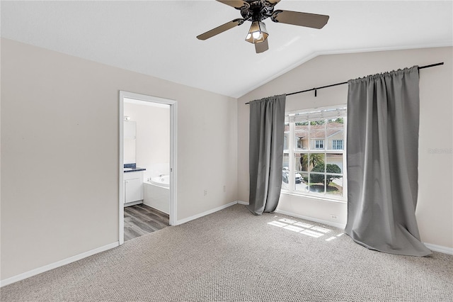unfurnished bedroom featuring connected bathroom, light colored carpet, a ceiling fan, vaulted ceiling, and baseboards