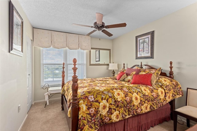 carpeted bedroom featuring baseboards, a ceiling fan, and a textured ceiling