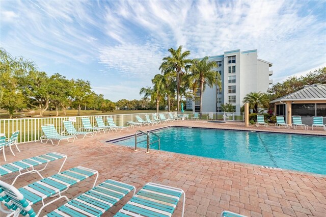 community pool featuring fence and a patio area