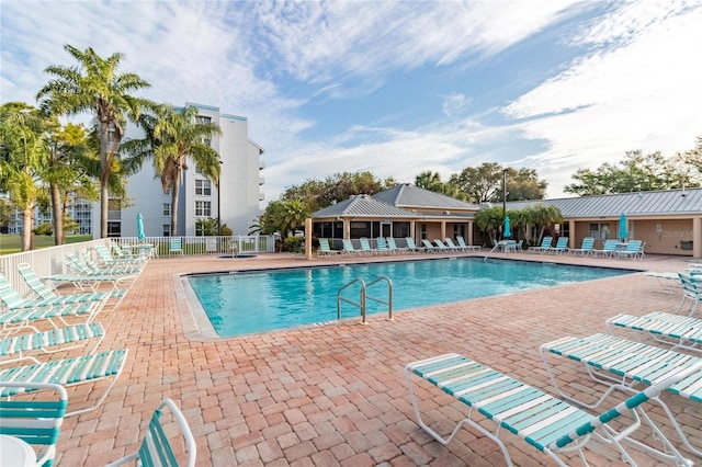 community pool featuring a patio and fence