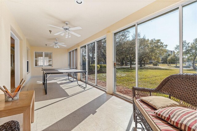 sunroom / solarium featuring plenty of natural light and ceiling fan