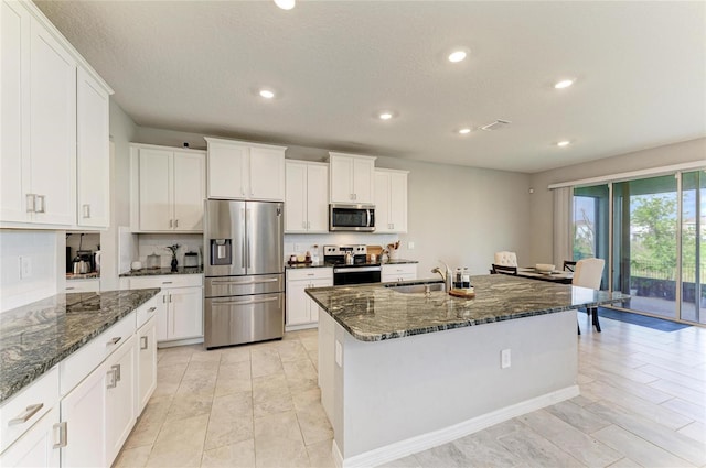 kitchen featuring appliances with stainless steel finishes, a sink, white cabinetry, and recessed lighting
