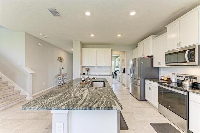kitchen featuring stainless steel appliances, a sink, visible vents, recessed lighting, and backsplash
