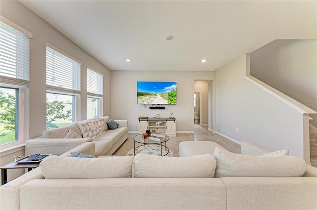living area featuring recessed lighting, a wealth of natural light, and baseboards