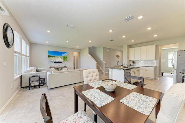 dining room featuring plenty of natural light, visible vents, recessed lighting, and stairway