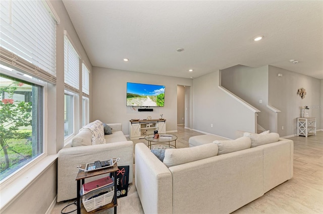 living area featuring recessed lighting, baseboards, stairs, and plenty of natural light