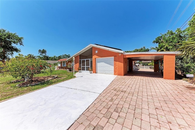 3053 Monica Pkwy, Sarasota, FL 34234 - view of front of property with a garage, driveway, a carport, and stucco siding