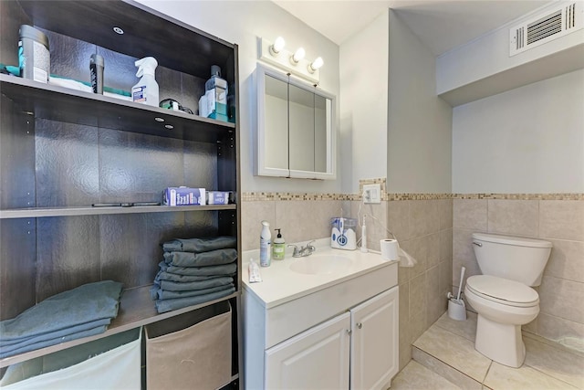 3053 Monica Pkwy, Sarasota, FL 34234 - bathroom featuring tile patterned floors, wainscoting, tile walls, toilet, and visible vents