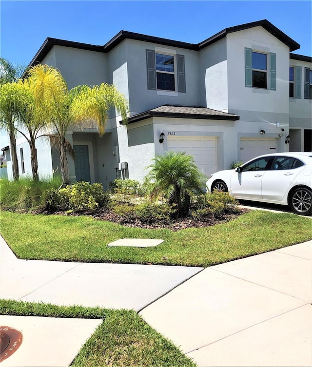 view of front facade with stucco siding, driveway, and a garage