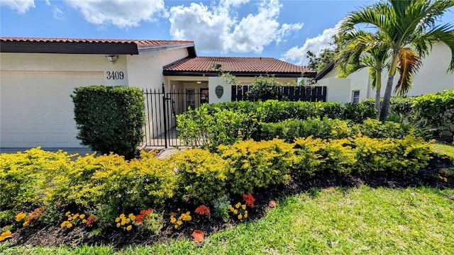 3409 Montilla Ct Unit 8410, Sarasota, FL 34232 - view of exterior entry with an attached garage, fence, a tile roof, and stucco siding