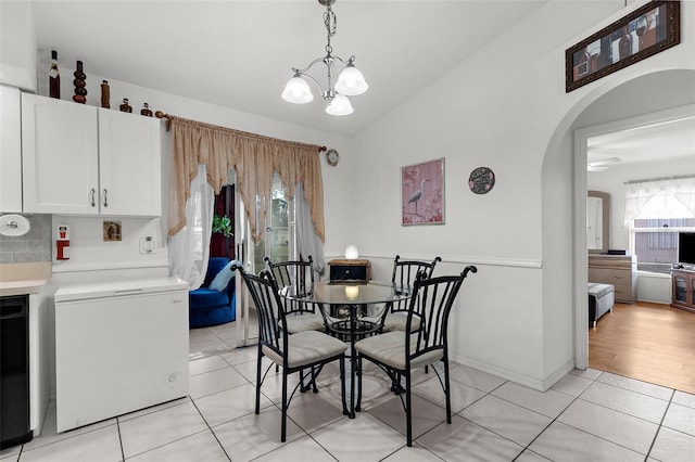3459 Lotus Rd, North Port, FL 34291 - dining room with light tile patterned flooring, vaulted ceiling, a notable chandelier, and arched walkways