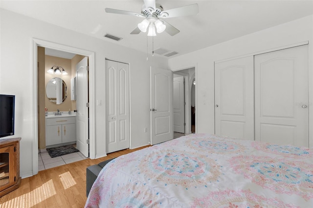 3459 Lotus Rd, North Port, FL 34291 - bedroom featuring multiple closets, a sink, light wood-style floors, visible vents, and ensuite bathroom