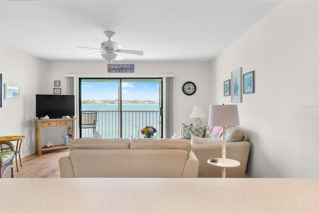 living area with light wood finished floors, baseboards, and ceiling fan