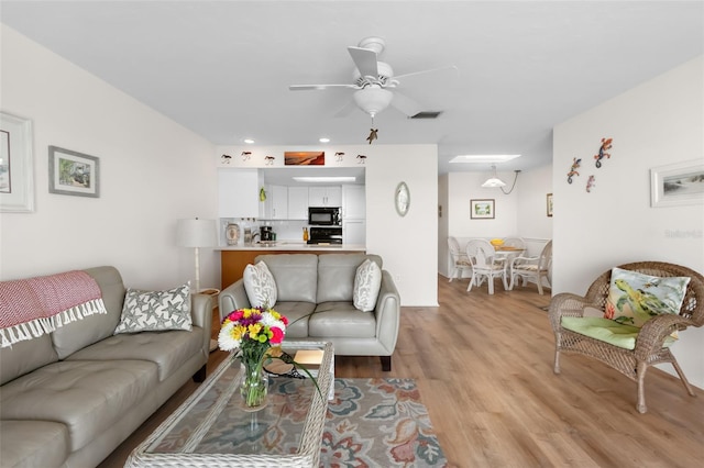 living area with a ceiling fan, visible vents, recessed lighting, and light wood-style floors