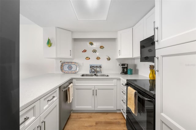 kitchen featuring light countertops, white cabinetry, a sink, and black appliances