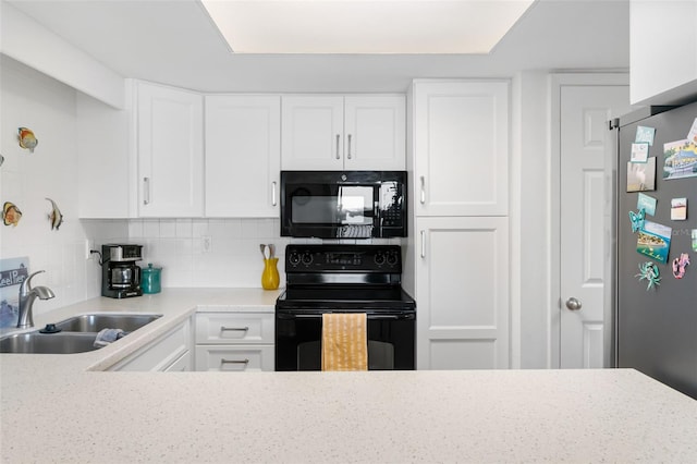 kitchen with light countertops, backsplash, a sink, black appliances, and white cabinetry