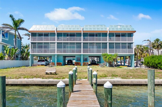 dock area with a lawn and a water view