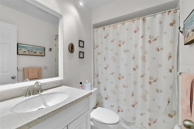 bathroom with curtained shower, toilet, and vanity