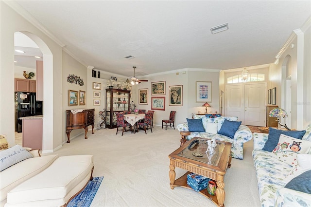 8136 Snowy Egret Pl, Bradenton, FL 34202 - living room featuring arched walkways, ornamental molding, light carpet, and a ceiling fan