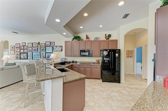 8136 Snowy Egret Pl, Bradenton, FL 34202 - kitchen with black appliances, arched walkways, a peninsula, recessed lighting, and a textured ceiling