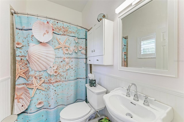 8136 Snowy Egret Pl, Bradenton, FL 34202 - bathroom featuring wainscoting, a decorative wall, and a shower with shower curtain