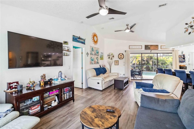 18033 Edgewater Dr, Port Charlotte, FL 33948 - living room featuring wood finished floors, lofted ceiling, ceiling fan, and visible vents