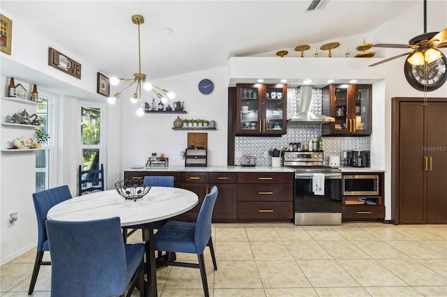 18033 Edgewater Dr, Port Charlotte, FL 33948 - interior space with light countertops, wall chimney exhaust hood, tasteful backsplash, dark brown cabinetry, and appliances with stainless steel finishes
