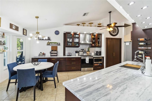 18033 Edgewater Dr, Port Charlotte, FL 33948 - kitchen with lofted ceiling, a sink, visible vents, wall chimney range hood, and appliances with stainless steel finishes
