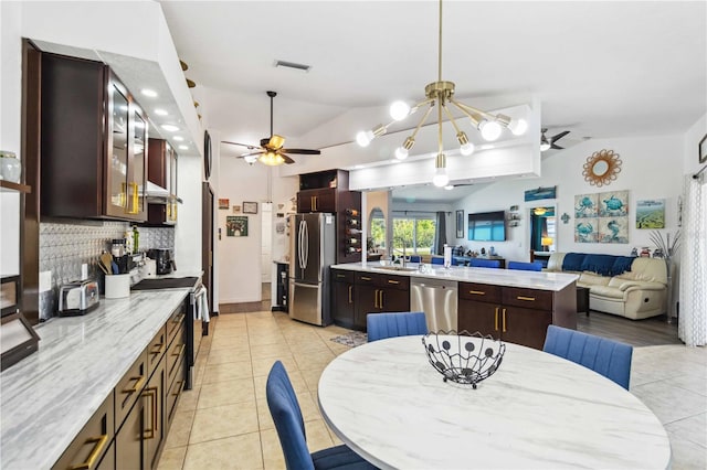 18033 Edgewater Dr, Port Charlotte, FL 33948 - dining area with light tile patterned flooring, ceiling fan, visible vents, and vaulted ceiling