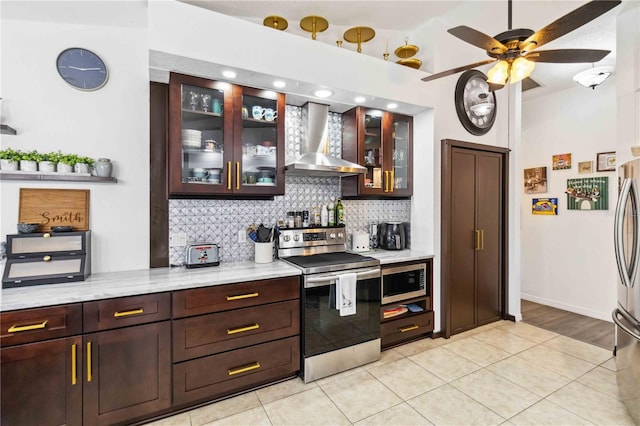 18033 Edgewater Dr, Port Charlotte, FL 33948 - kitchen featuring tasteful backsplash, stainless steel appliances, ceiling fan, dark brown cabinets, and wall chimney exhaust hood