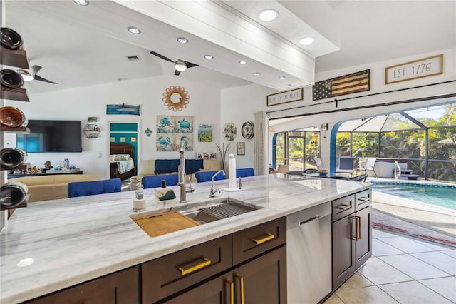18033 Edgewater Dr, Port Charlotte, FL 33948 - kitchen with light stone counters, a sink, stainless steel dishwasher, open floor plan, and light tile patterned floors