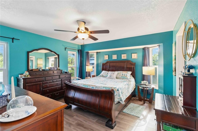 18033 Edgewater Dr, Port Charlotte, FL 33948 - bedroom with a ceiling fan, multiple windows, and wood finished floors