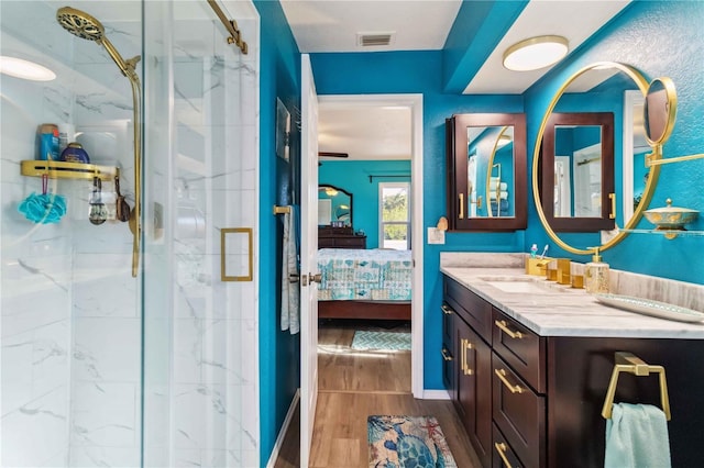 18033 Edgewater Dr, Port Charlotte, FL 33948 - ensuite bathroom with vanity, a marble finish shower, ensuite bath, visible vents, and wood finished floors