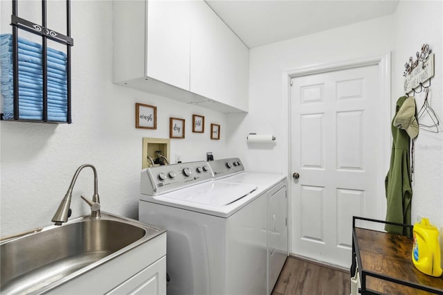 18033 Edgewater Dr, Port Charlotte, FL 33948 - clothes washing area with washer and clothes dryer, cabinet space, a sink, and dark wood-style flooring