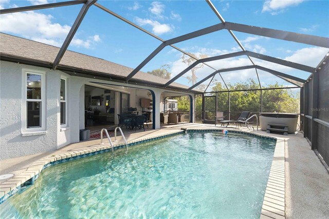18033 Edgewater Dr, Port Charlotte, FL 33948 - pool with glass enclosure, a patio area, and a hot tub